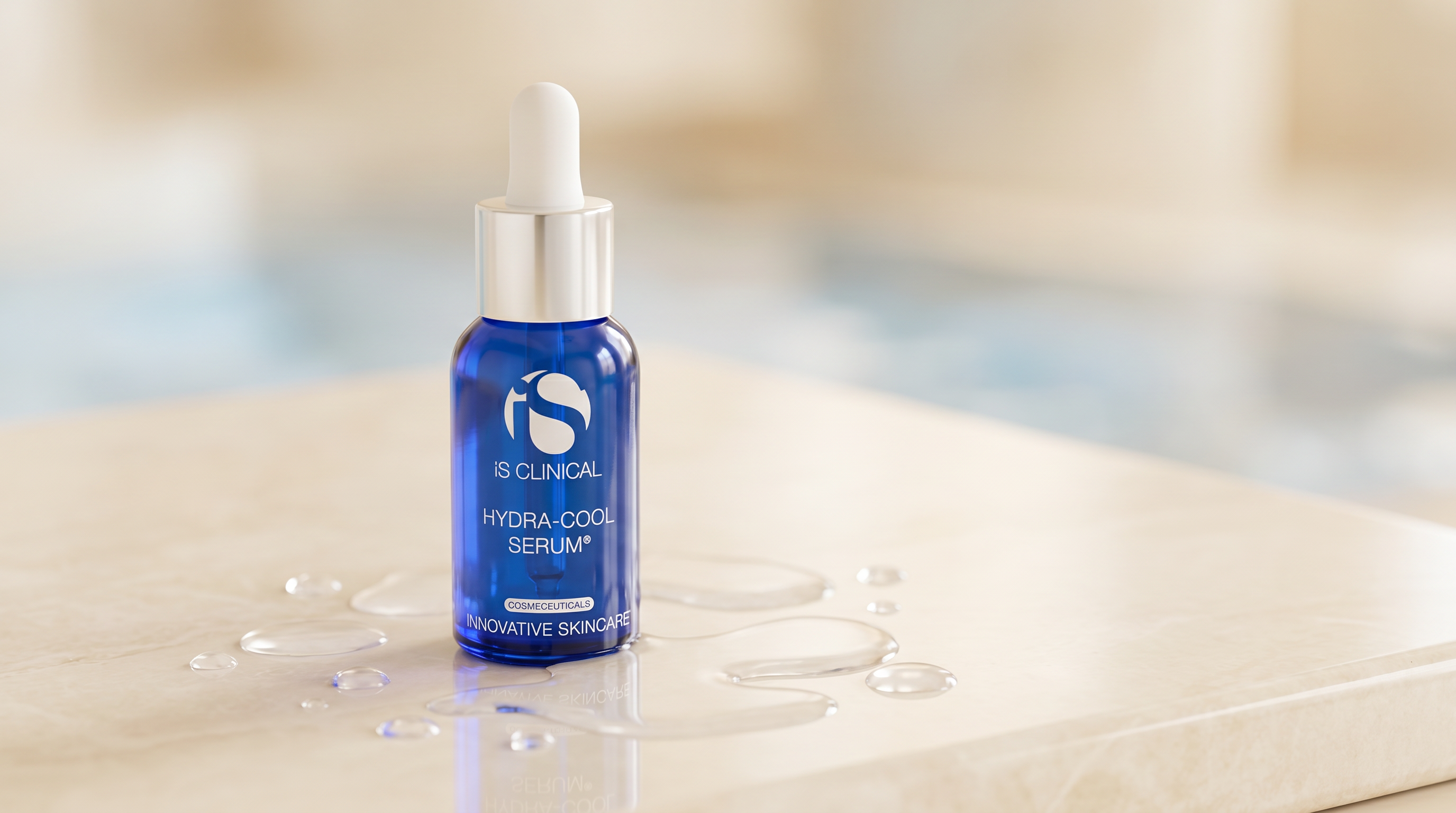 iS Clinical Hydra-Cool Serum bottle on a cream surface with delicate water droplets.